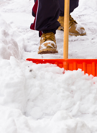 Close-up of a person clearing snow with a shovel